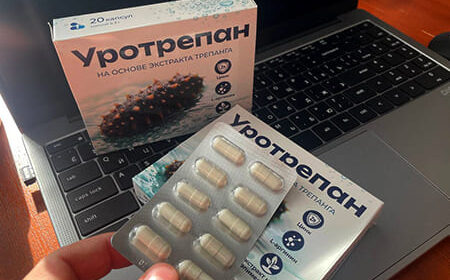 Упаковка и блистер с капсулами Уротрепана над клавиатурой.